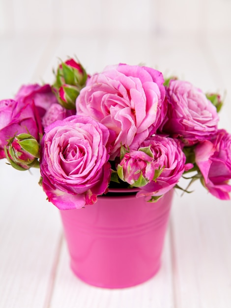 Roses roses (pivoine) dans un vase sur une table en bois blanc. fleurs