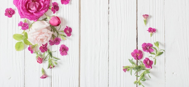 Roses roses et rouges sur fond de bois blanc