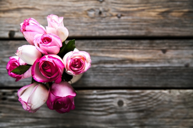 Roses roses sur une table en bois. Ancien