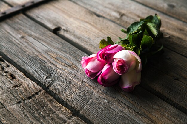 Roses roses sur une table en bois