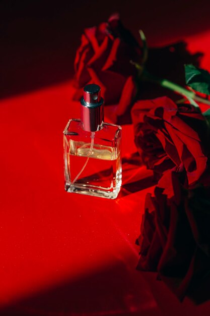 roses rouges et concept de traitement de beauté de bouteille de parfum