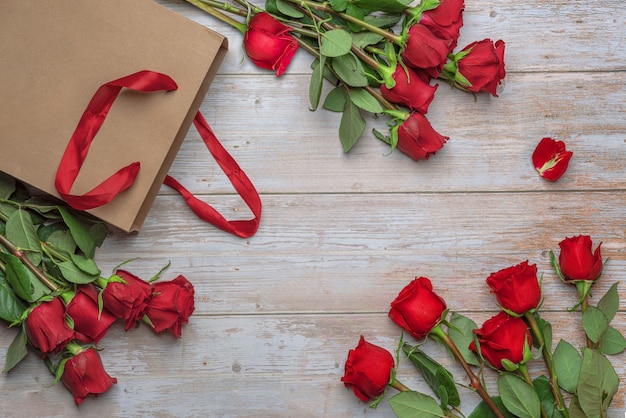 Roses rouges dans un sac à provisions artisanal une surface en bois Livraison de fleurs pour la Saint-Valentin le 14 février