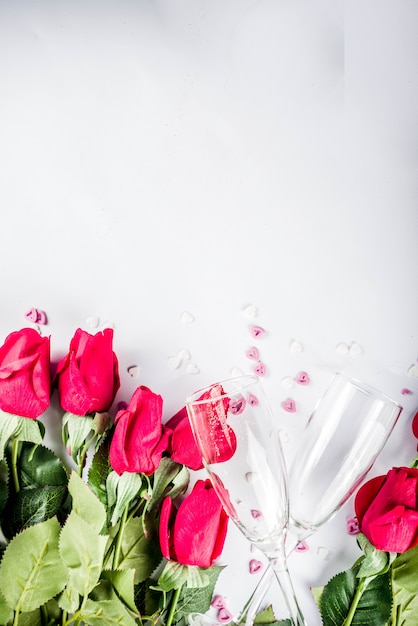 Roses rouges avec deux verres de champagne