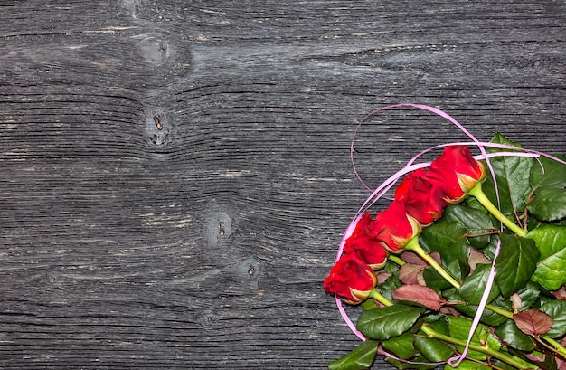 Roses rouges sur fond de bois. Carte pour la Saint Valentin. Vue de dessus.