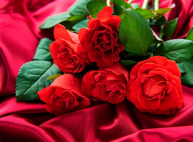 Roses rouges sur fond de soie rouge