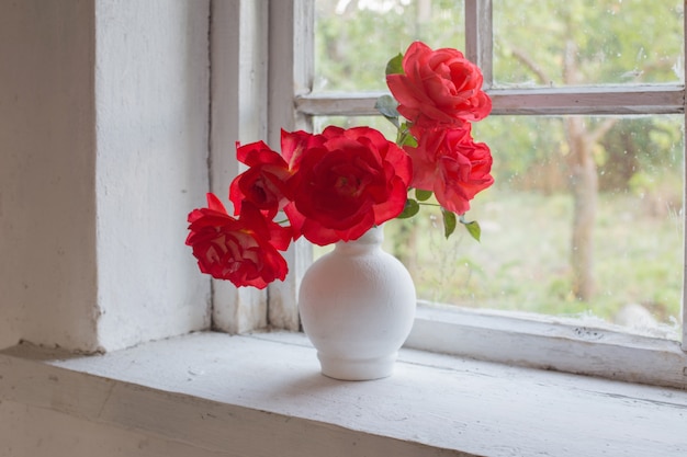 Roses rouges sur le rebord de la fenêtre