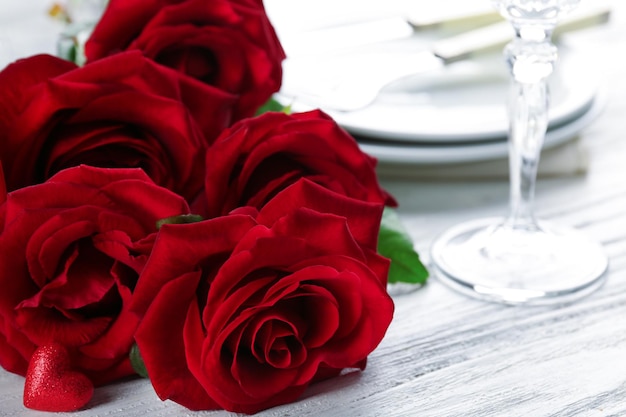 Roses rouges sur la table de vacances servie