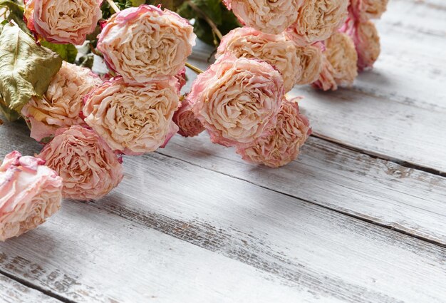 Photo des roses sèches sur un fond en bois clair