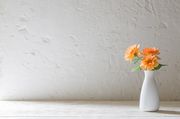 Roses en vase sur fond mur blanc