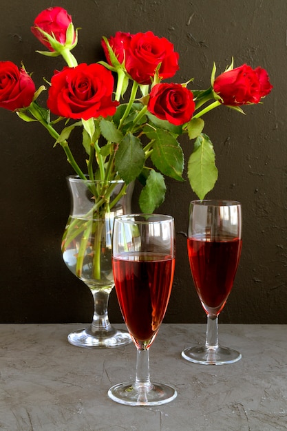 Roses et vin sur fond noir.