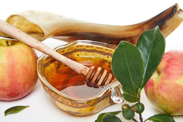 Rosh hashanah concept de vacances du nouvel an juif Un bol en forme de pomme avec des pommes au miel un shofar sont des symboles traditionnels de la fête Isolé sur fond blanc