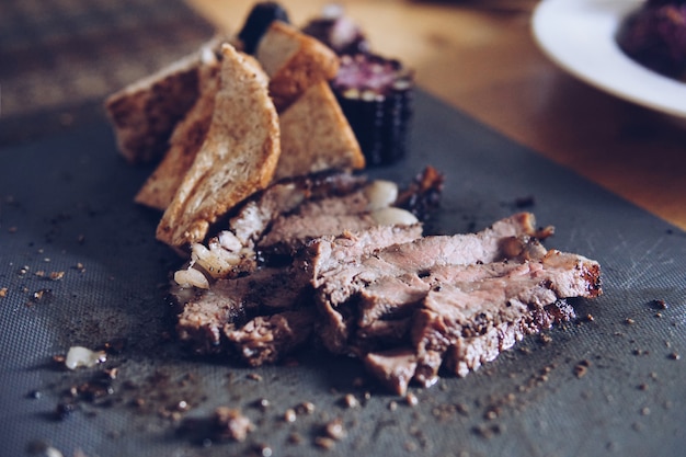 Rôti de boeuf flou, maïs, pain servi sur la table.