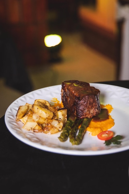 Rôti de bœuf gastronomique avec pommes de terre et asperges servi sur une assiette