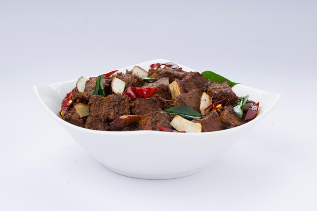 Rôti de boeuf masala ou curry recette maison disposée dans un bol blanc avec un fond blanc