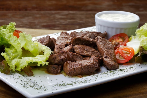 Rôti de boeuf avec pommes de terre et salade et un verre de bière