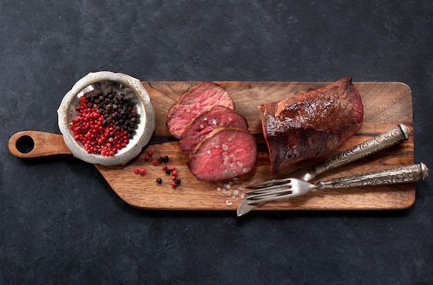 Rôti de boeuf sur une vue de dessus de planche de bois