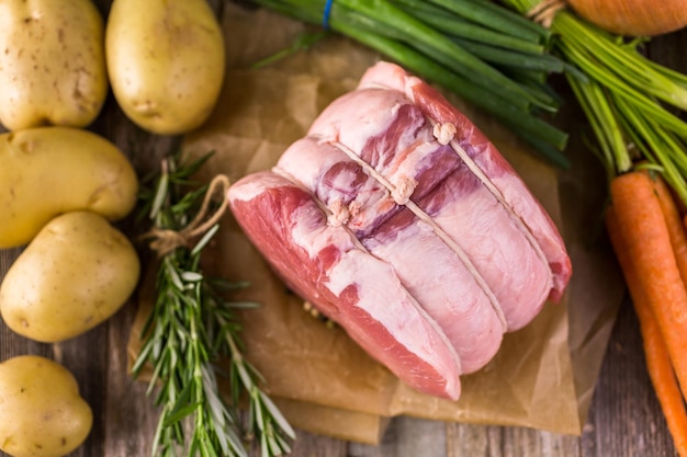 Rôti de lion de porc bio au romarin sur table de ferme en bois.