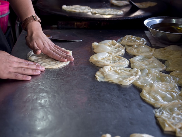 Roti Making, roti thresh farine by roti maker with oil. Cuisine de rue traditionnelle indienne.