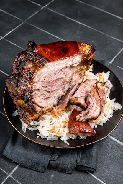 Rôti de porc Jarret de jarret avec choucroute sur une assiette Fond noir Vue de dessus