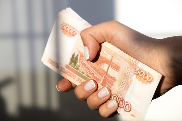 Roubles d'argent russe Cinq millièmes billets en espèces Une pile d'argent dans une main féminine avec une manucure française