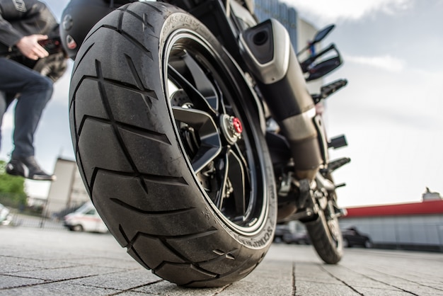 Roue arrière de la moto rouge dans la rue de la ville