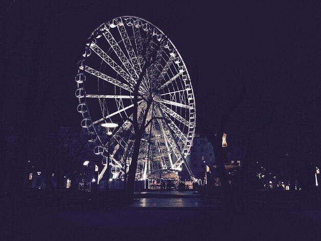 Photo la roue de ferris éclairée dans le parc contre le ciel