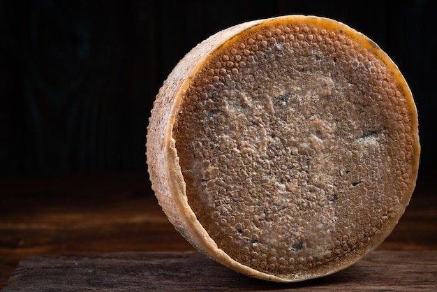 Roue de fromage entière sur planche de bois