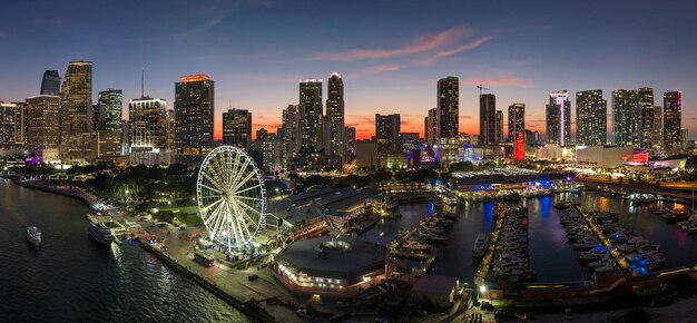 La roue d'observation de Miami et Skyviews à Bayside Marketplace avec des reflets dans l'eau de la baie de Biscayne et les gratte-ciel du centre financier de la ville de Brickell