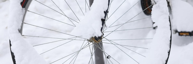 La roue de vélo est recouverte de neige sur le concept de stockage de vélos de rue