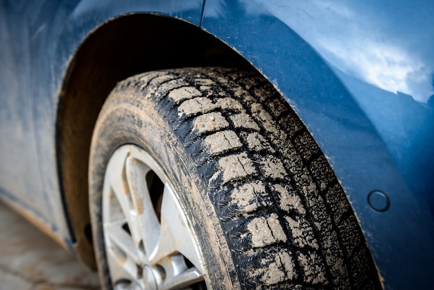 Roue de voiture sale avec un spray de marais sur la voiture.