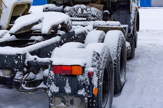 Les roues et le châssis du tracteur sont recouverts de neige Panne de voiture par mauvais temps