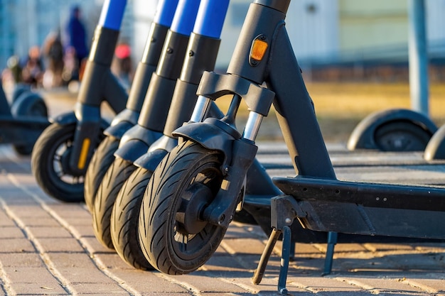 Photo roues de scooters électriques d'affilée à une distance proche transport urbain moderne respectueux de l'environnement