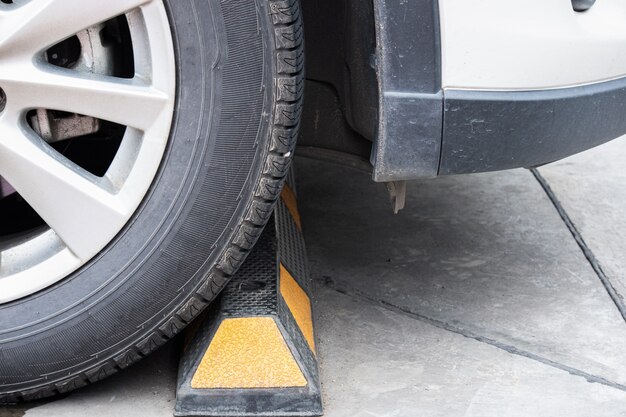 Photo les roues de la voiture sont bloquées par des tiges de ciment dans le parking