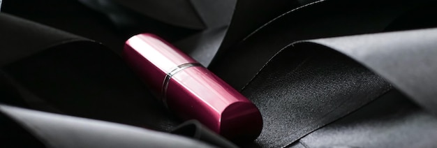 Rouge à lèvres rose sur fond de soie noire maquillage de luxe et cosmétique de beauté