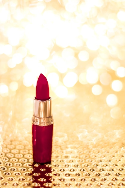 Photo rouge à lèvres rouge foncé sur noël doré nouvel an et saint valentin fond de paillettes de vacances produit de maquillage et de cosmétiques pour la marque de beauté de luxe