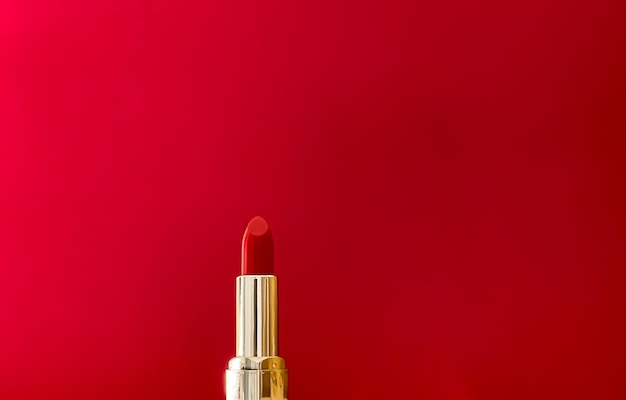 Rouge à lèvres rouge en tube doré sur fond de couleur maquillage de luxe et cosmétiques pour la conception de produits de marque de beauté