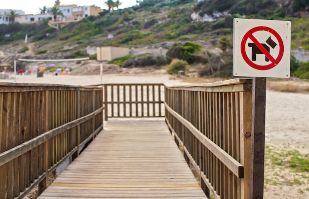 Rouge et noir chiens interdits signe sur chemin en bois menant à la plage