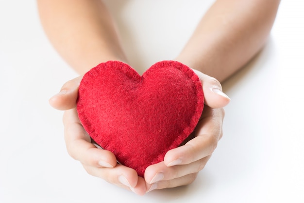 Rouge senti le coeur dans les mains de l&#39;enfant sur le blanc.