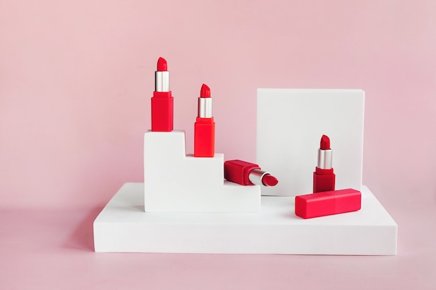 Rouges à lèvres rouges sur un podium blanc avec des formes géométriques