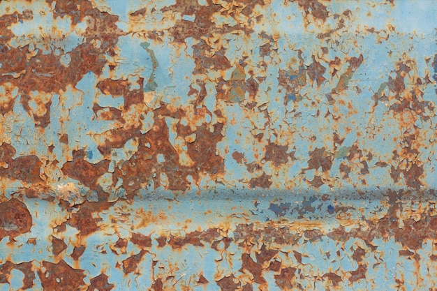 Rouille brune et orange sur métal bleu ancien.