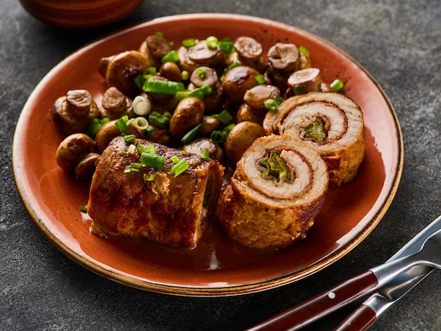 Roulade de porc aux cornichons et bacon servi avec champignons frits et oignons verts