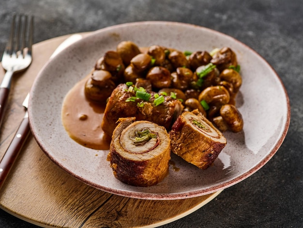 Roulade de porc aux cornichons et bacon servi avec champignons frits et oignons verts