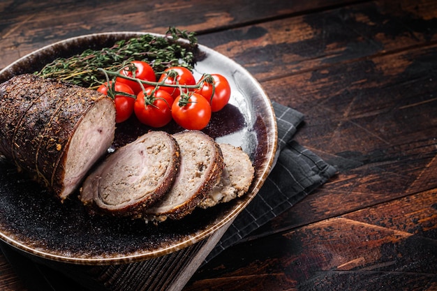 Roulade de porc rôti en tranches Porchetta sur une assiette avec des épices Fond en bois Vue de dessus Espace de copie