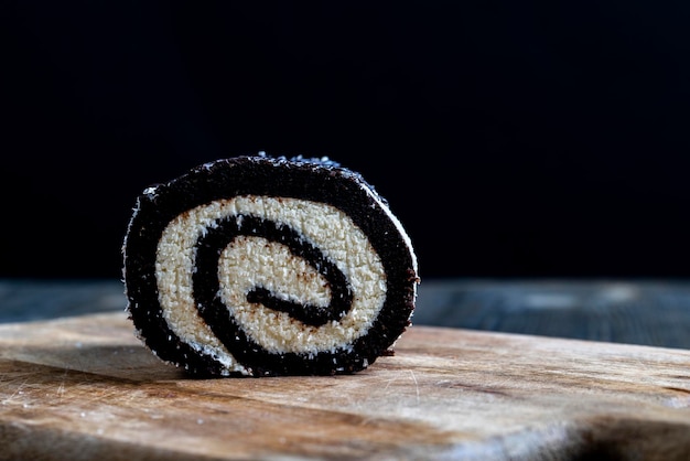 Rouleau au chocolat avec une couche de caillé crémeux dans des copeaux de noix de coco