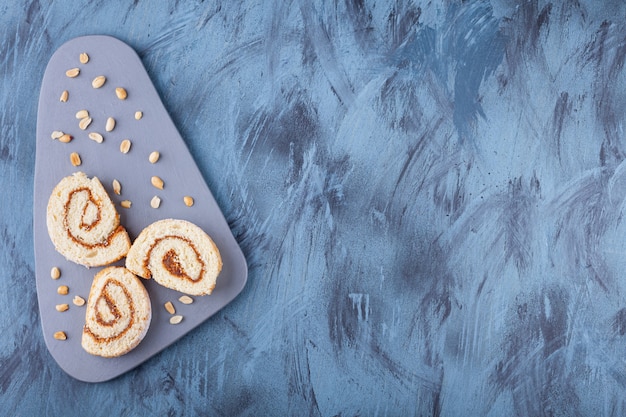 Rouleau de biscuits en tranches avec garniture au chocolat placé sur une planche grise.