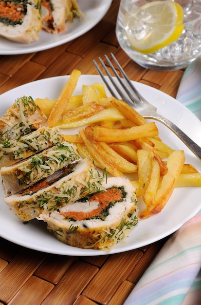 Rouleau de blanc de poulet aux épinards et carottes sous une croûte de parmesan