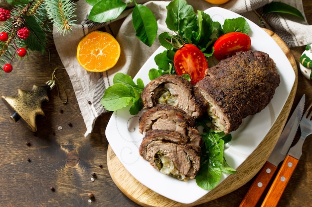 Rouleau de boeuf farci à la poire et au fromage sur une table de Noël festive Copy space