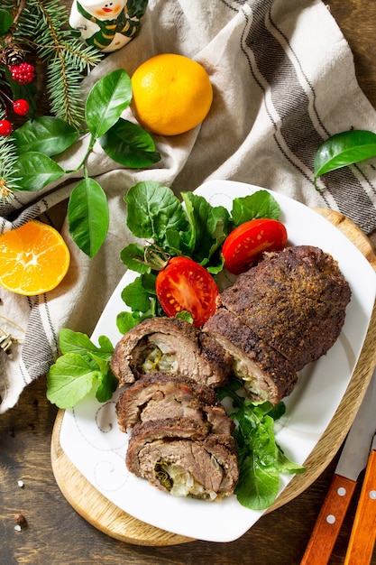 Rouleau de boeuf farci à la poire et au fromage sur une table de Noël festive