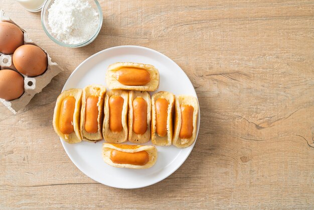 Photo rouleau de crêpes plat avec saucisse