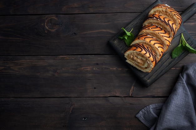 Rouleau éponge à dessert avec crème au chocolat et feuilles de menthe